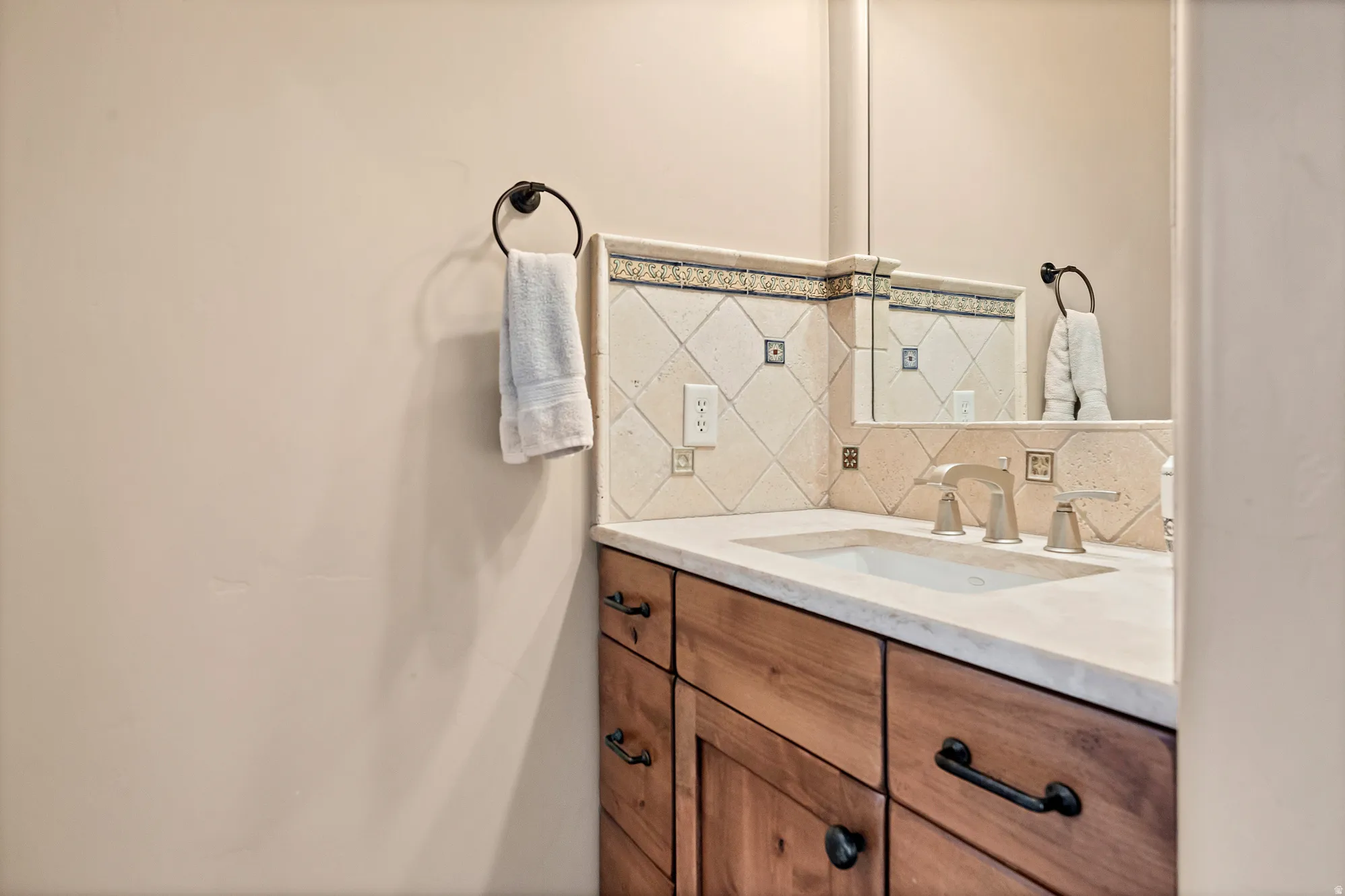 Bathroom featuring vanity and backsplash