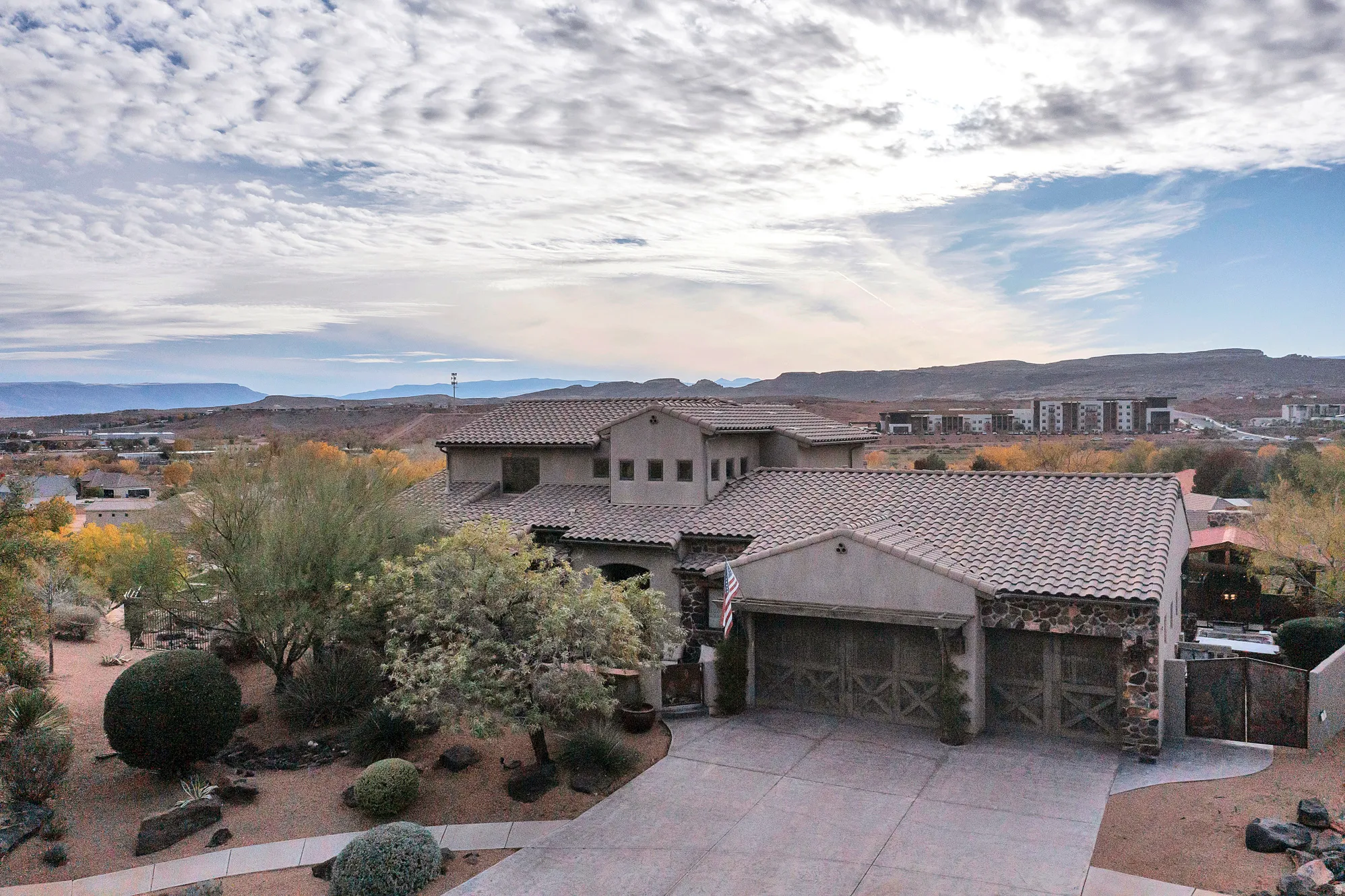 Mediterranean / spanish-style home featuring a mountain view, an attached garage, driveway, stucco siding, and a tile roof