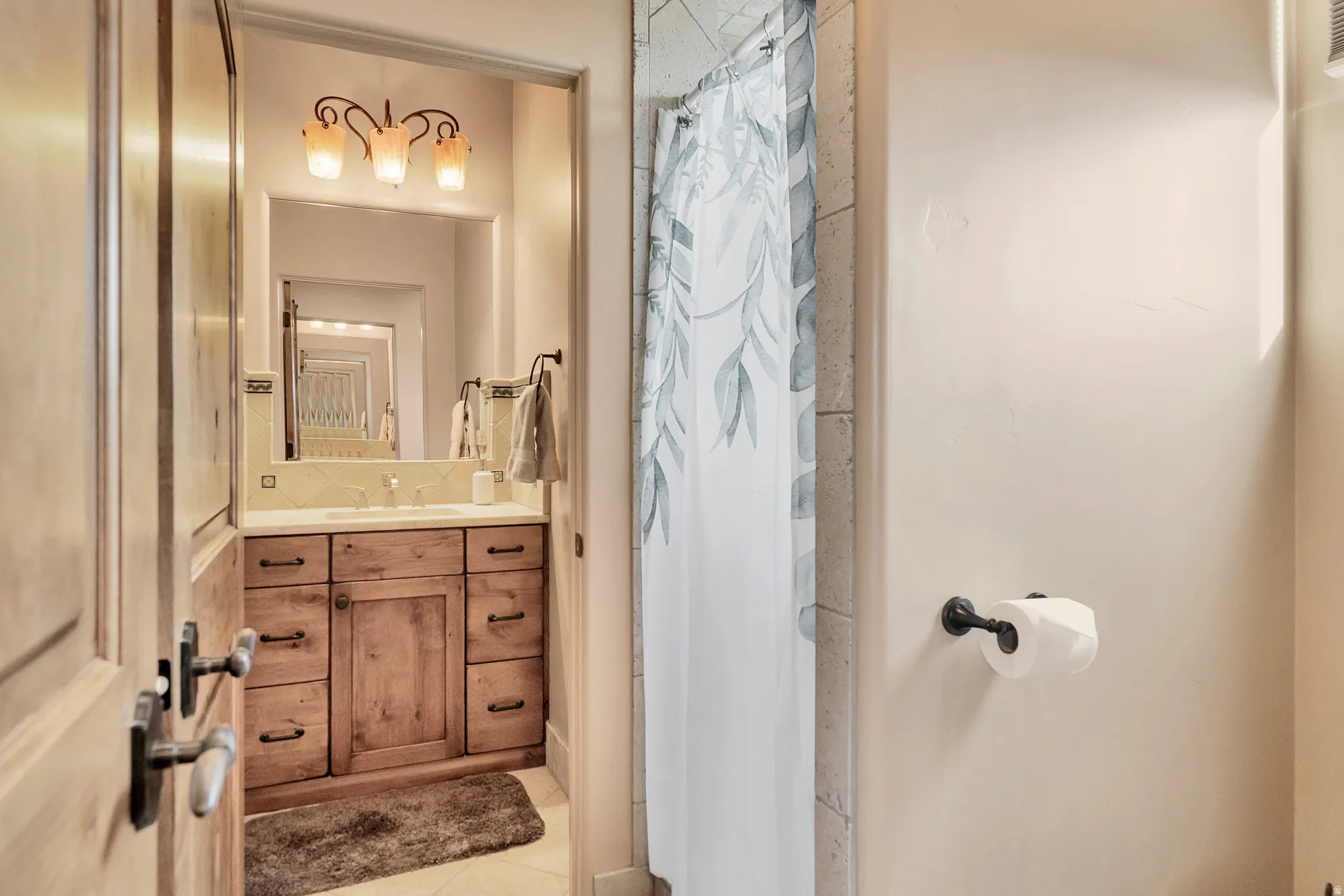 Full bathroom with vanity, a shower with shower curtain, and light tile patterned floors