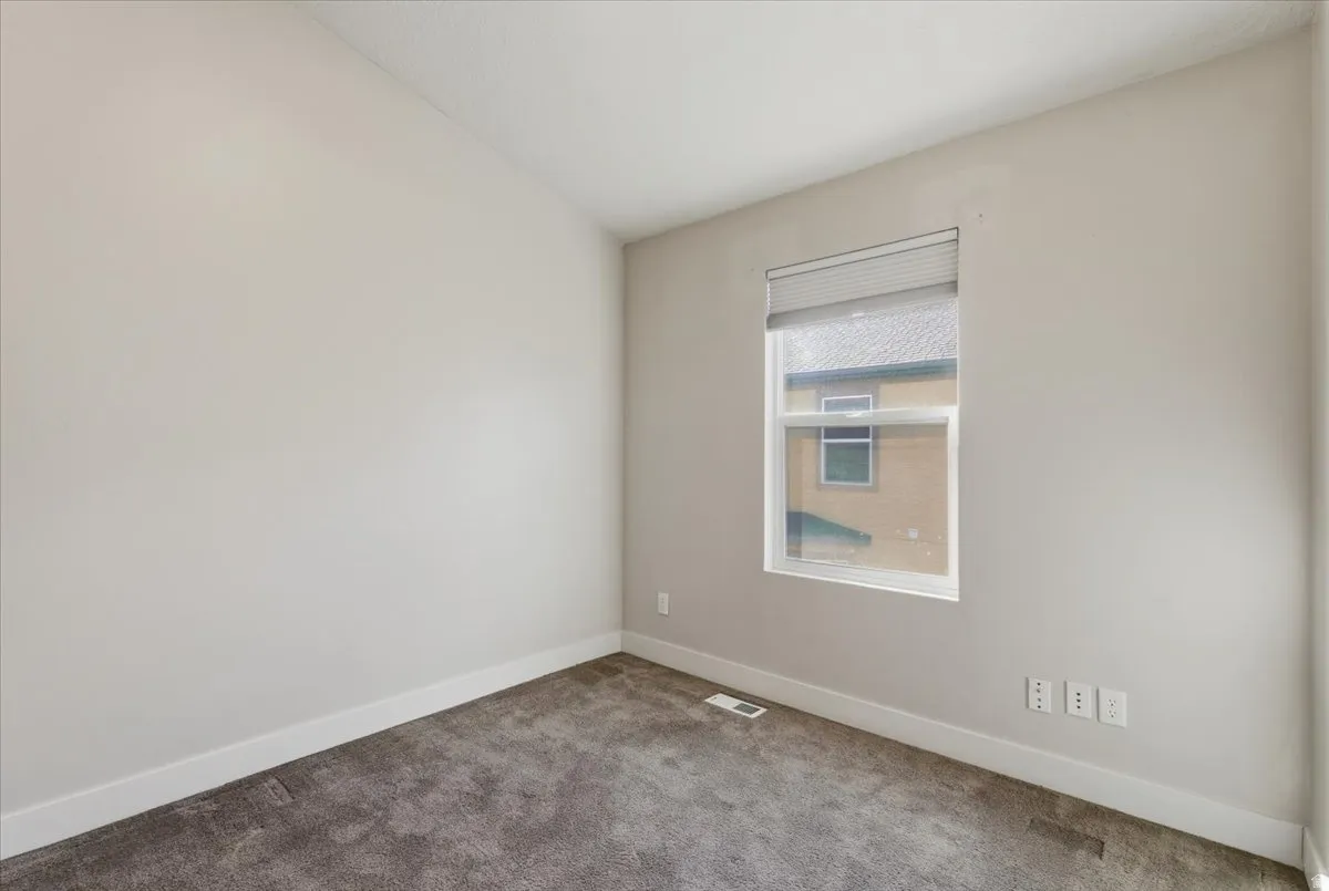 Spare room with carpet and lofted ceiling