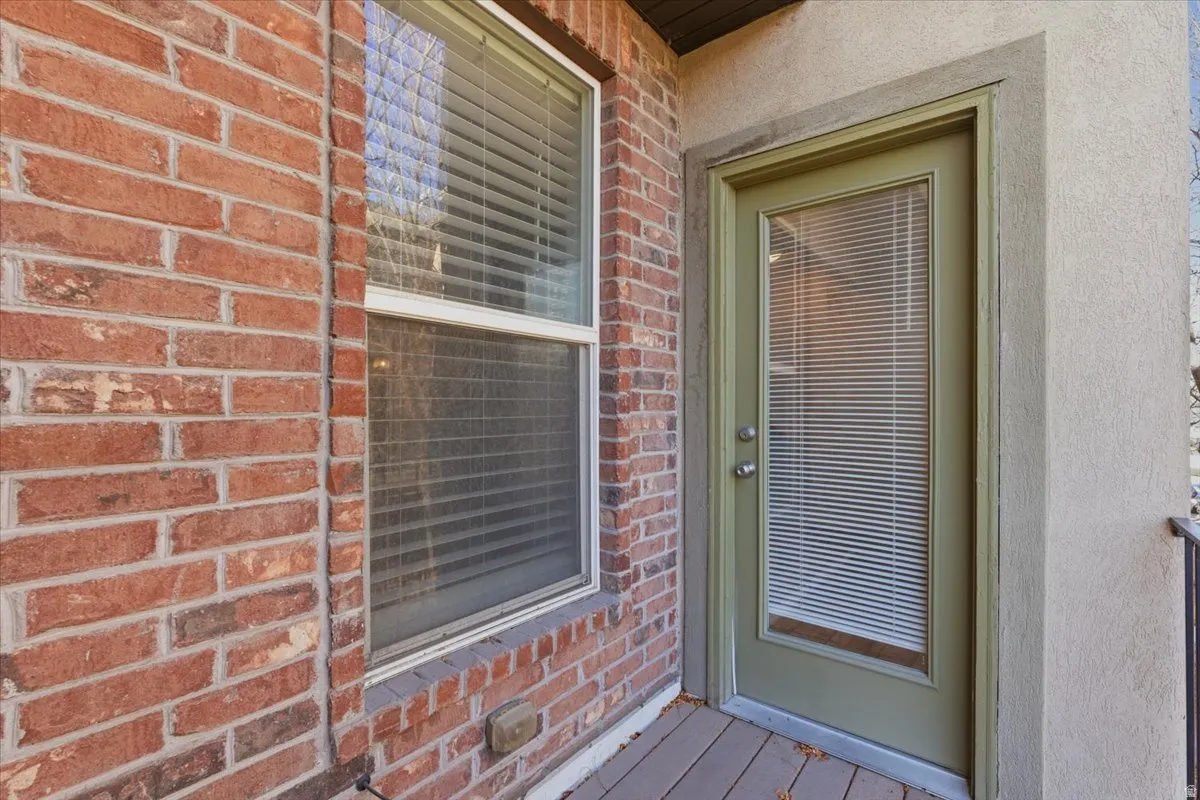 Entrance to property featuring brick siding and stucco siding