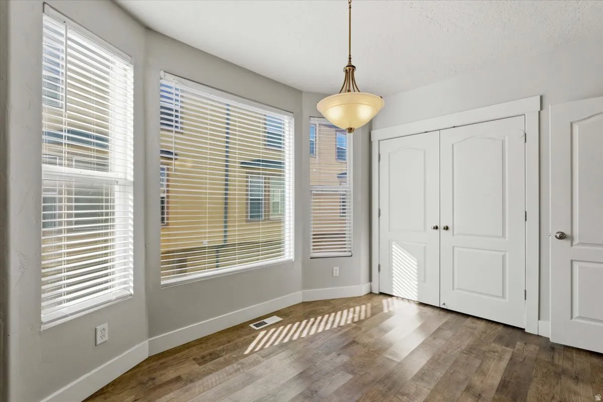 Unfurnished dining area featuring baseboards and dark wood-type flooring