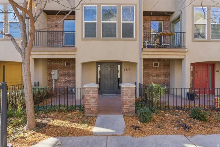 Property entrance featuring brick siding and stucco siding