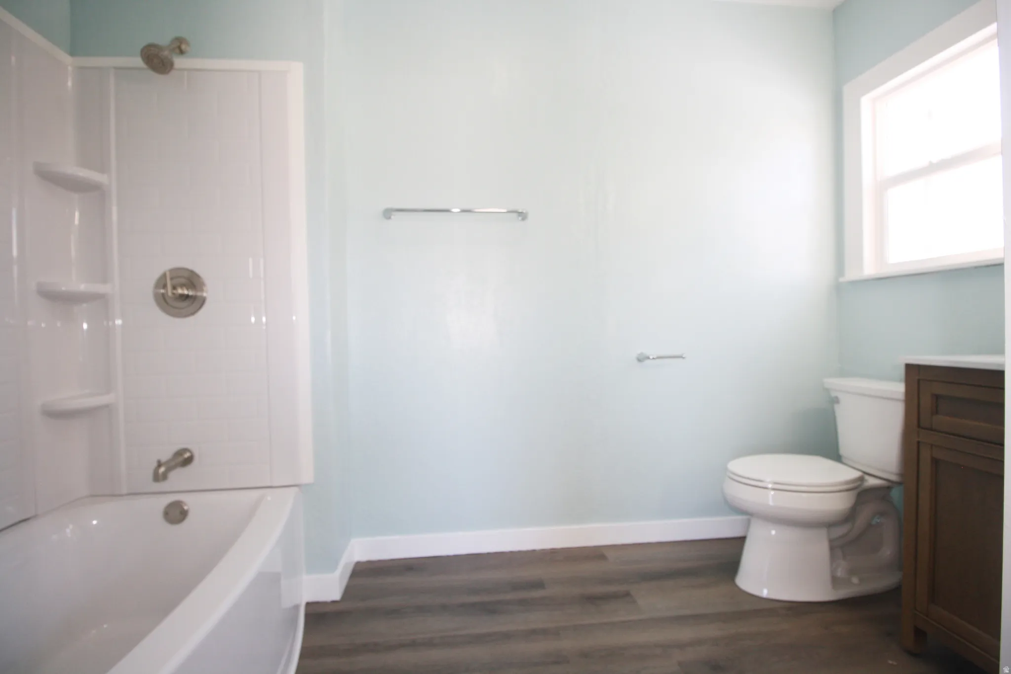Master en-suite bathroom with bathing tub / shower combination, dark wood finished floors, and vanity