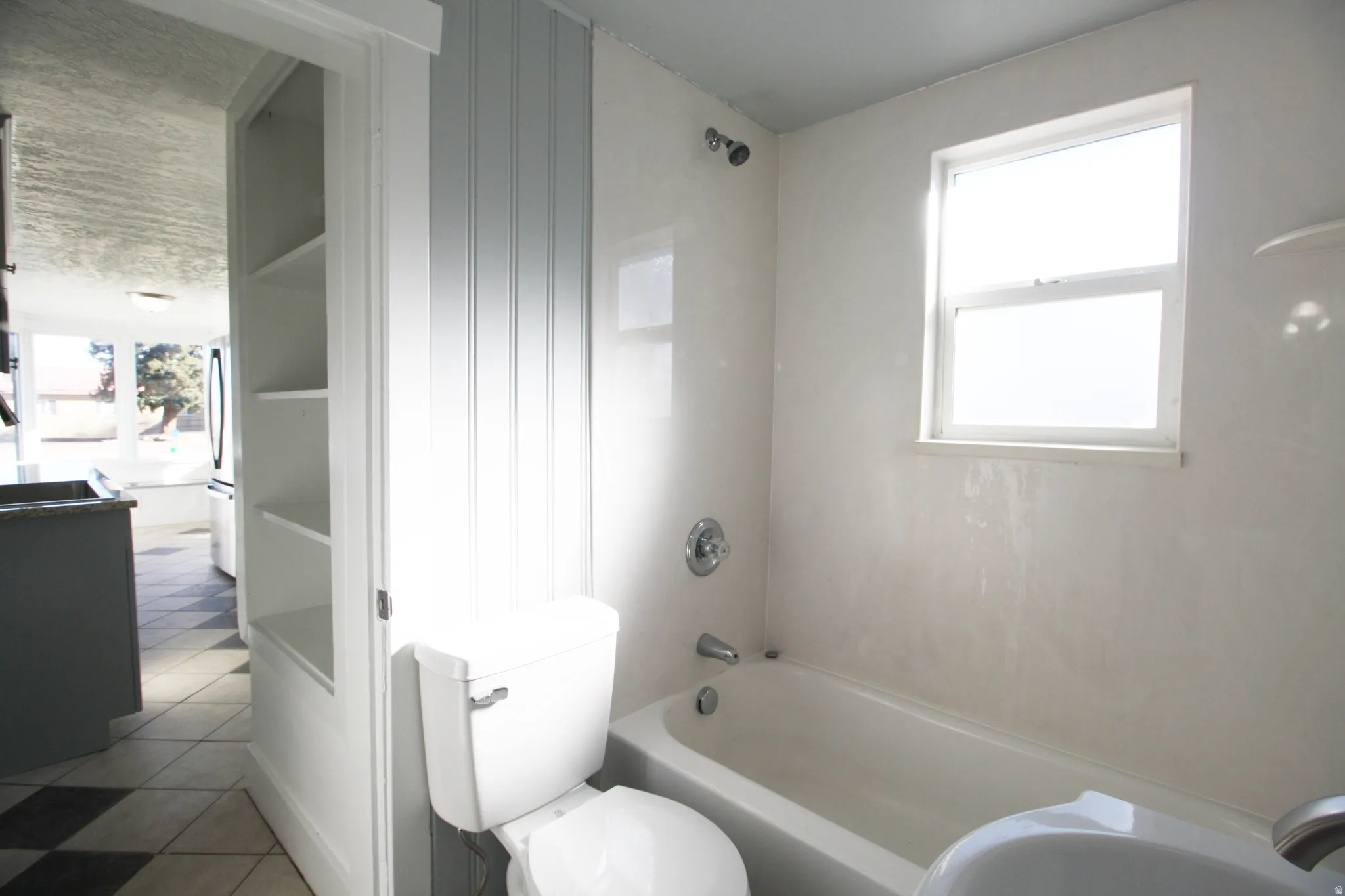 Main Bathroom featuring bathing tub / shower combination, plenty of natural light, and tile patterned floors