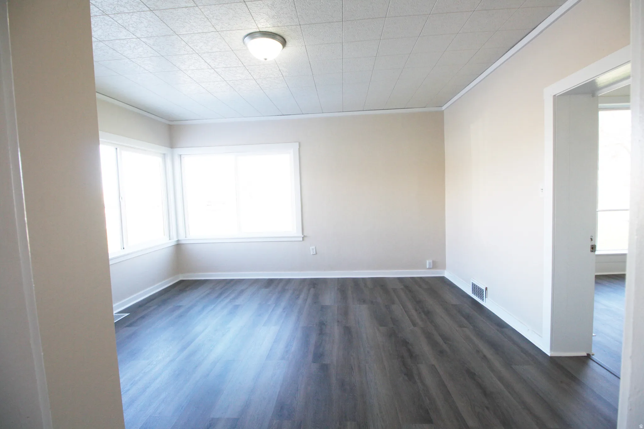 Bedroom 2 with ornamental molding, dark wood finished floors, and plenty of natural light
