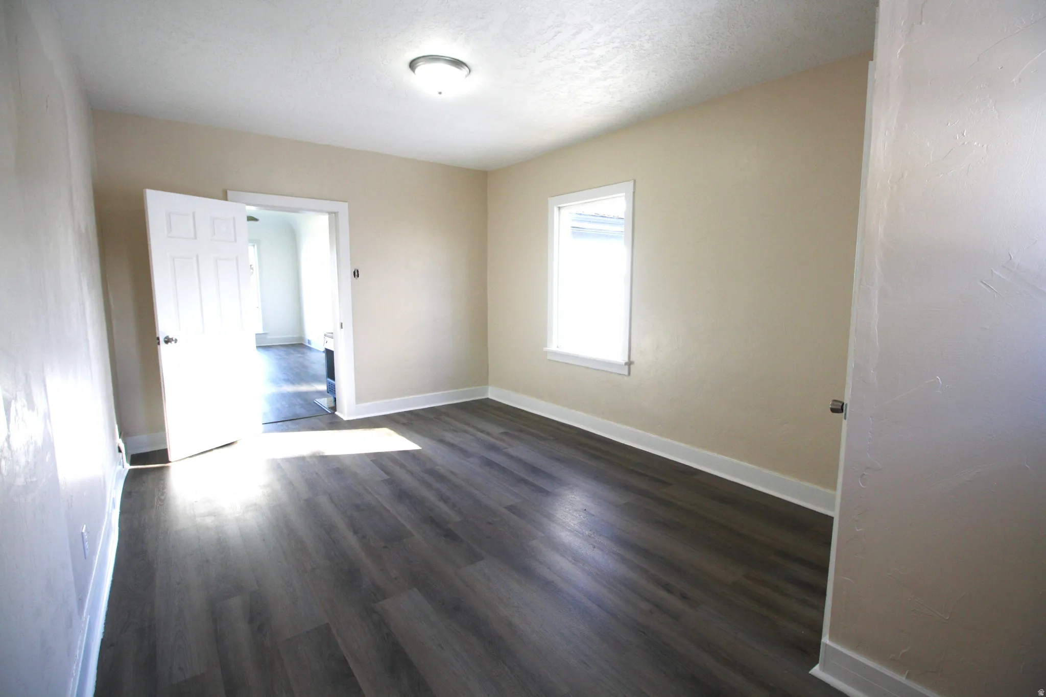 Bedroom 3 featuring dark wood-style flooring and a textured ceiling