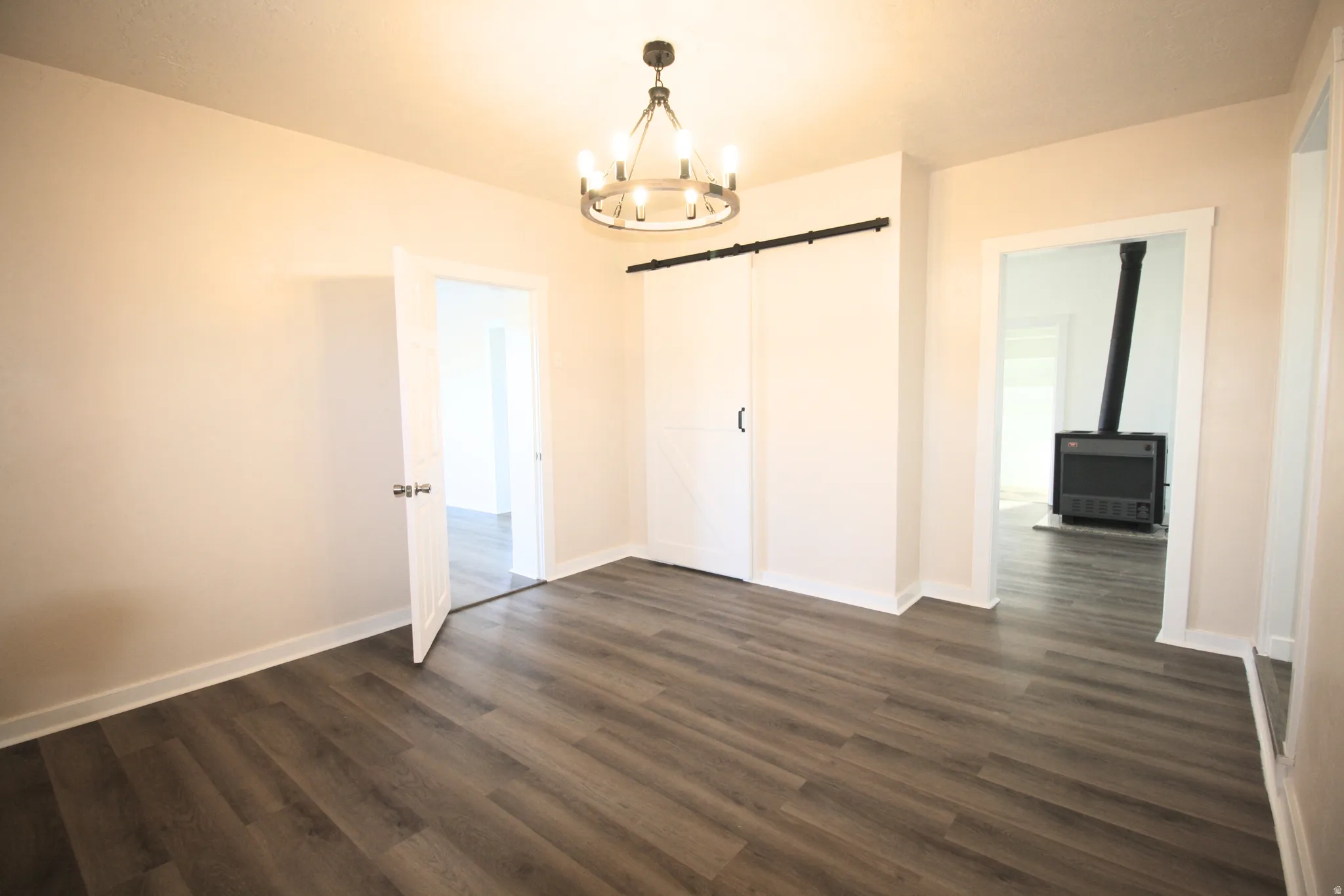 Formal Living area with a barn door, a chandelier, and dark wood-style floors