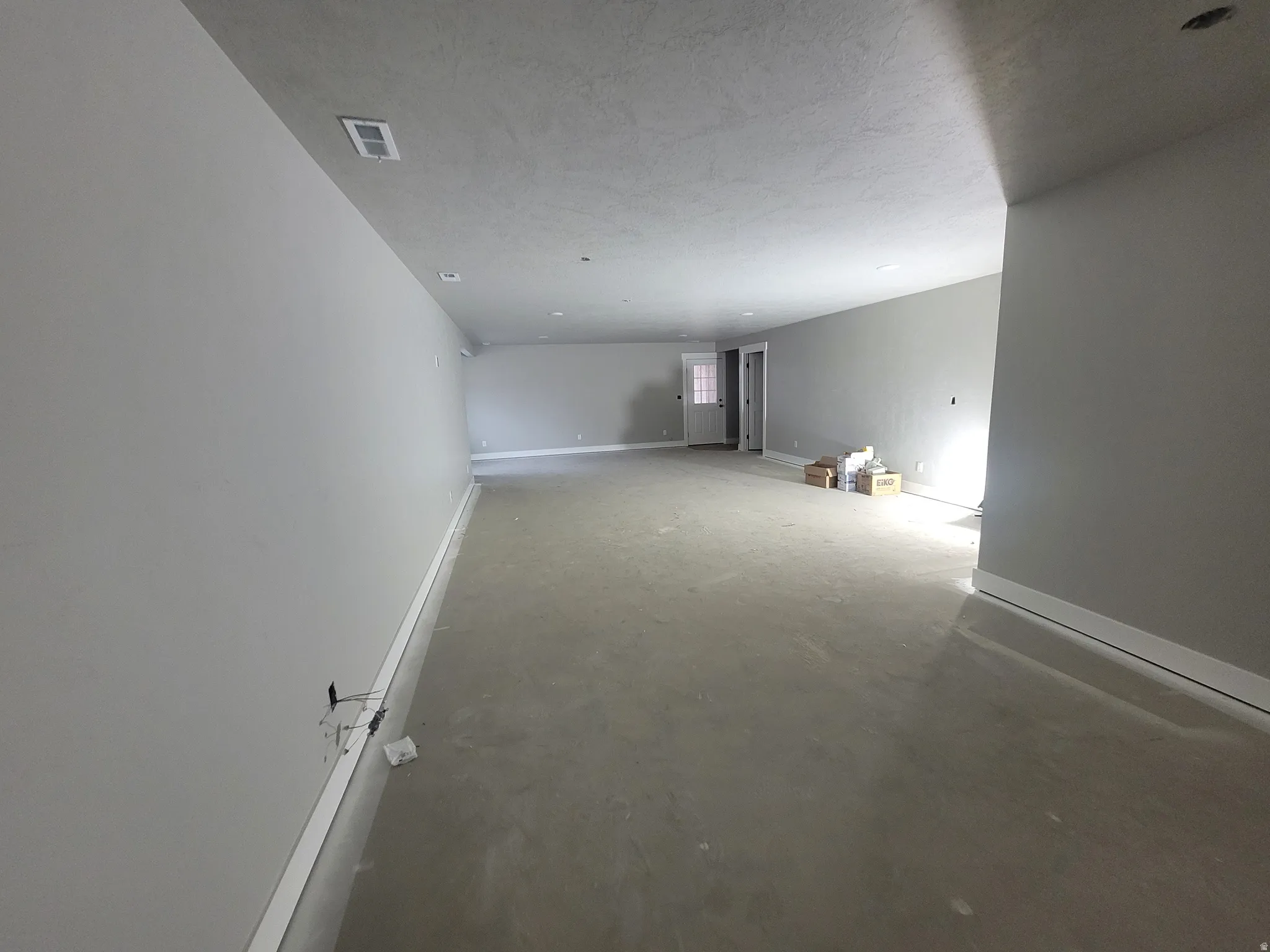 Empty room featuring concrete floors and baseboards