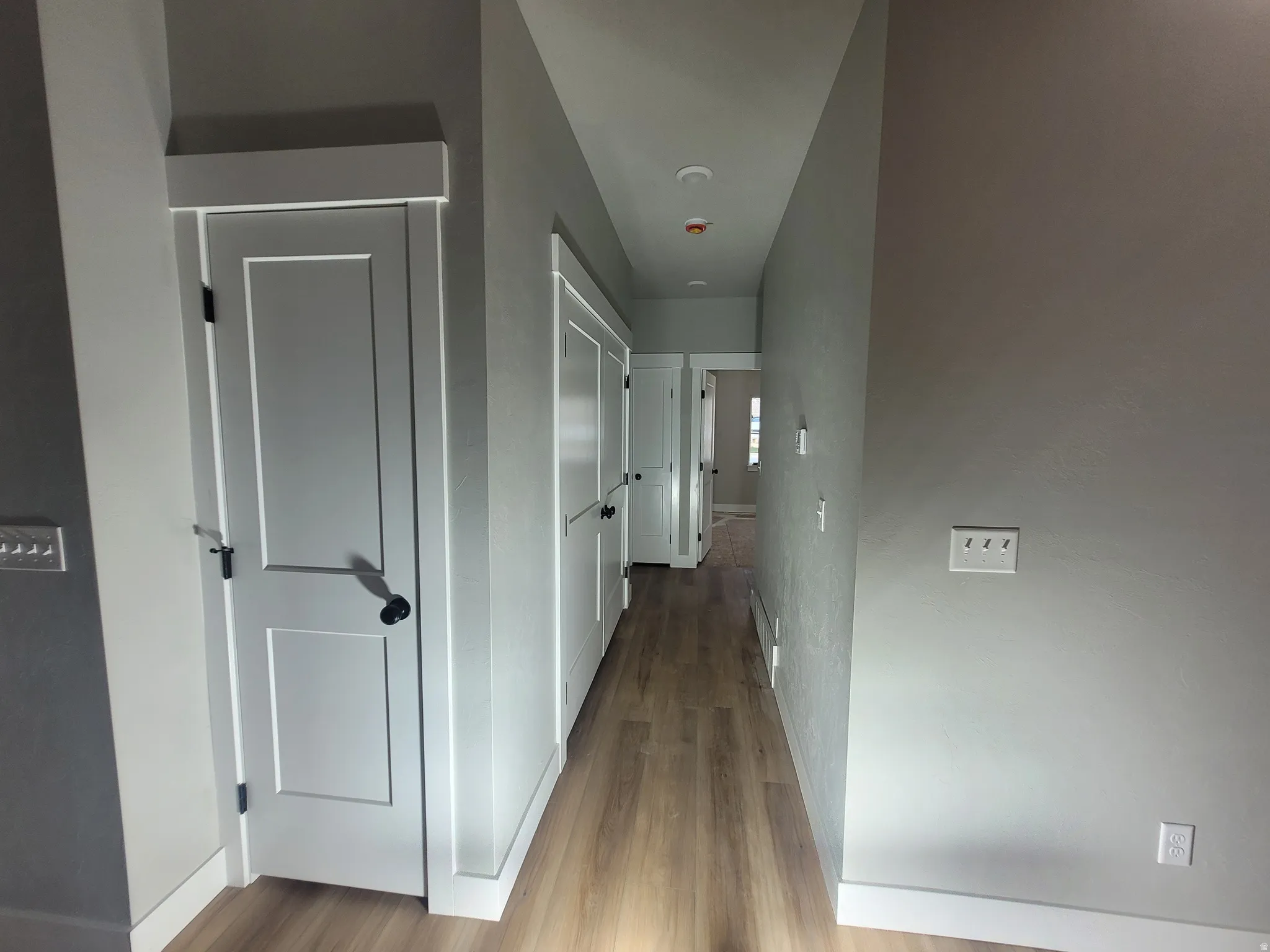 Hall featuring light wood-type flooring and baseboards