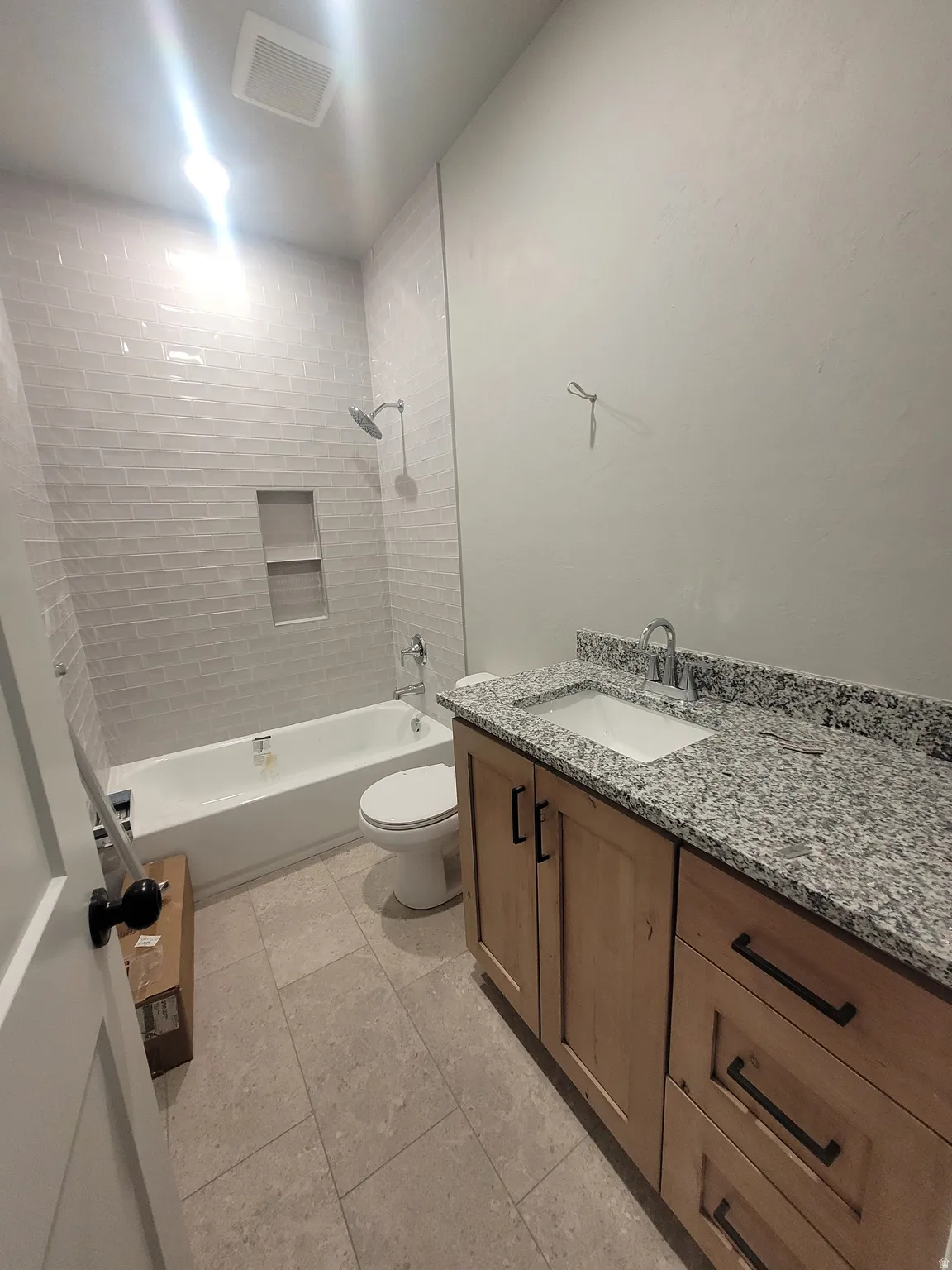Full bath featuring vanity, bathtub / shower combination, and light tile patterned floors
