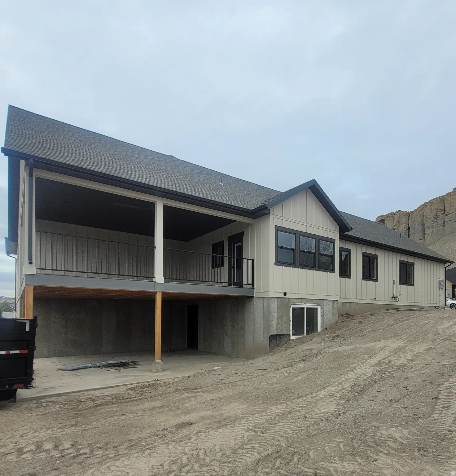 Back of property with a shingled roof, a balcony, and board and batten siding