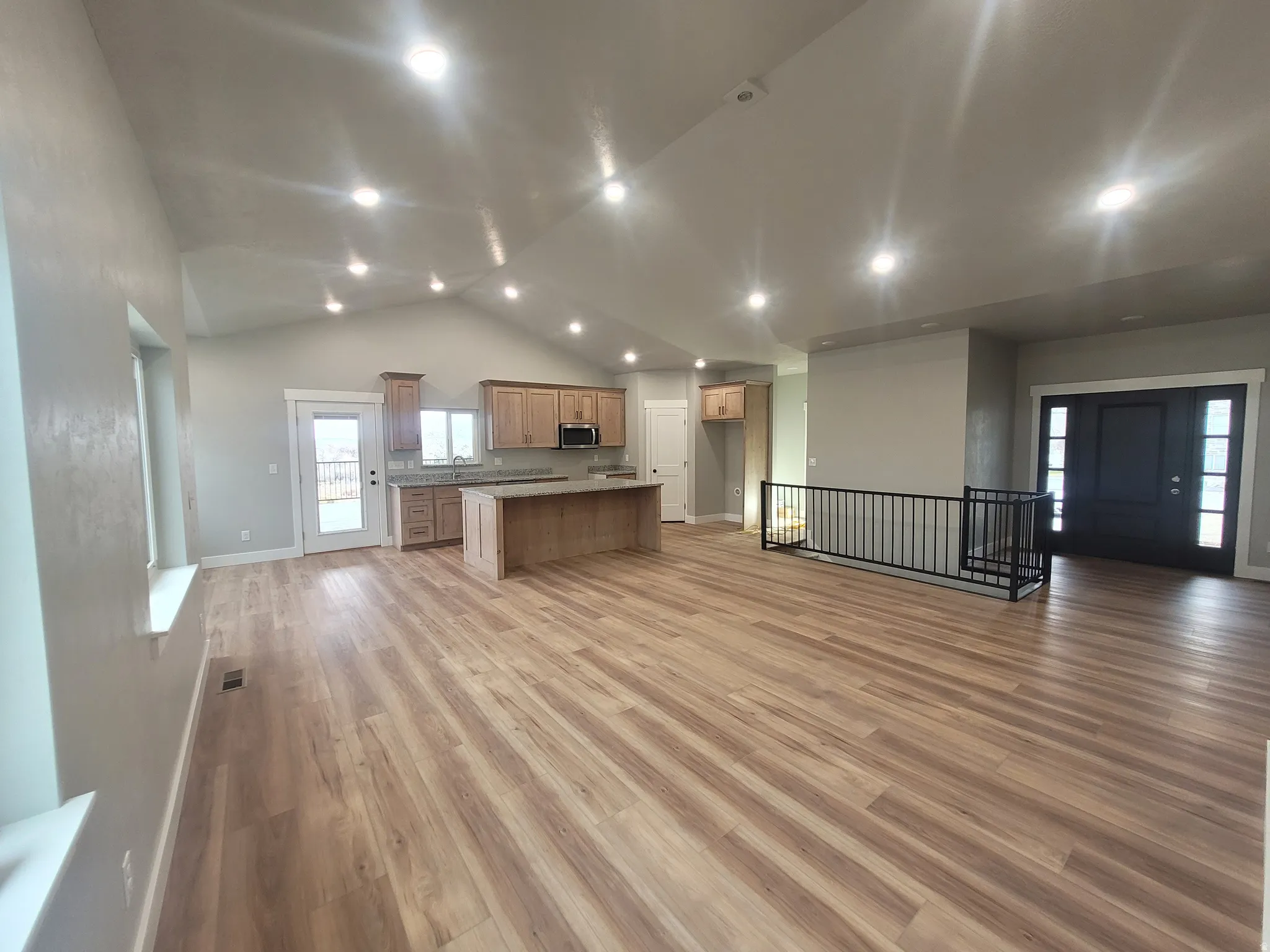 Unfurnished living room featuring light wood-type flooring, high vaulted ceiling, and recessed lighting