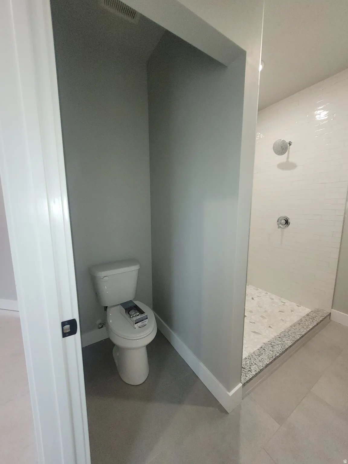 Full bathroom featuring a shower stall and baseboards