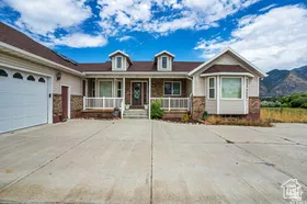 View of front of house featuring covered porch, driveway, and an attached garage
