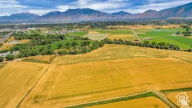 Aerial view of sparsely populated area featuring a mountain backdrop and extensive farmland