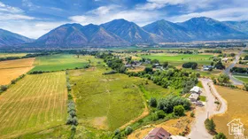 View of rural area with a mountain backdrop and large plots for crops