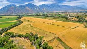 Aerial view of sparsely populated area featuring a mountain backdrop and abundant farmland