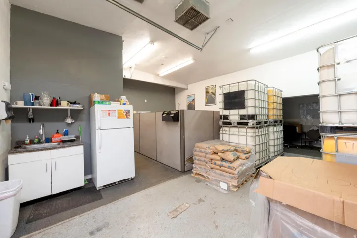 Misc room with a desk, a garage, and concrete flooring