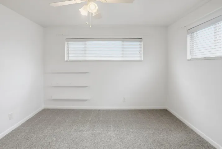 Unfurnished room with light carpet and a ceiling fan