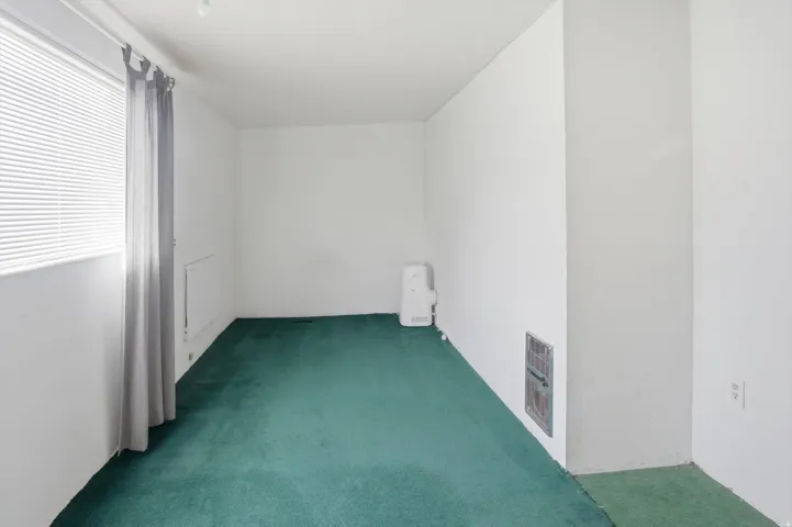 Empty room featuring dark colored carpet