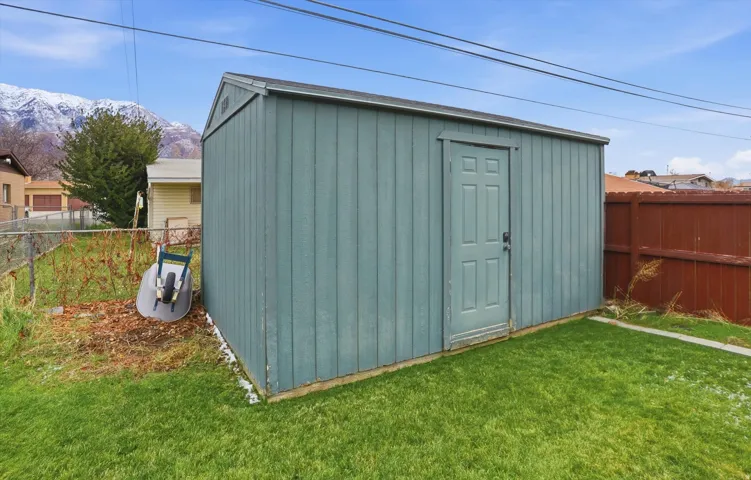 View of shed with a fenced backyard and a mountain view
