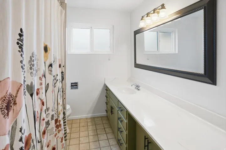 Bathroom with vanity, a shower with curtain, and light tile patterned floors