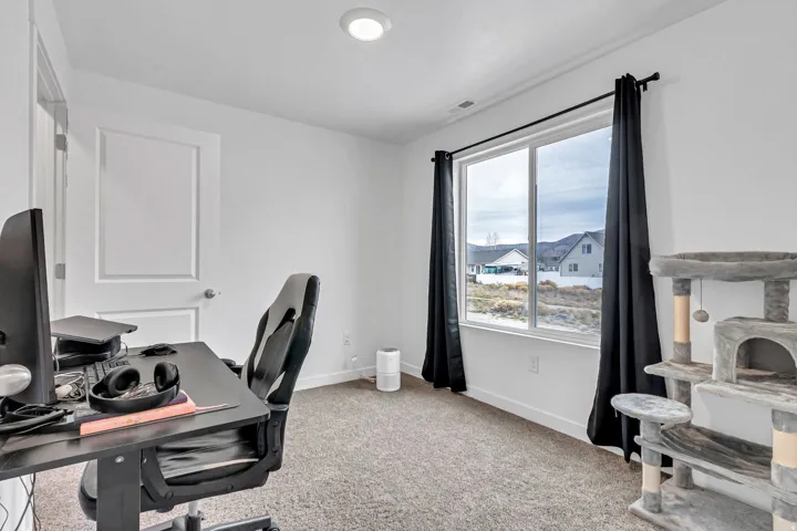 Home office featuring light carpet and baseboards
