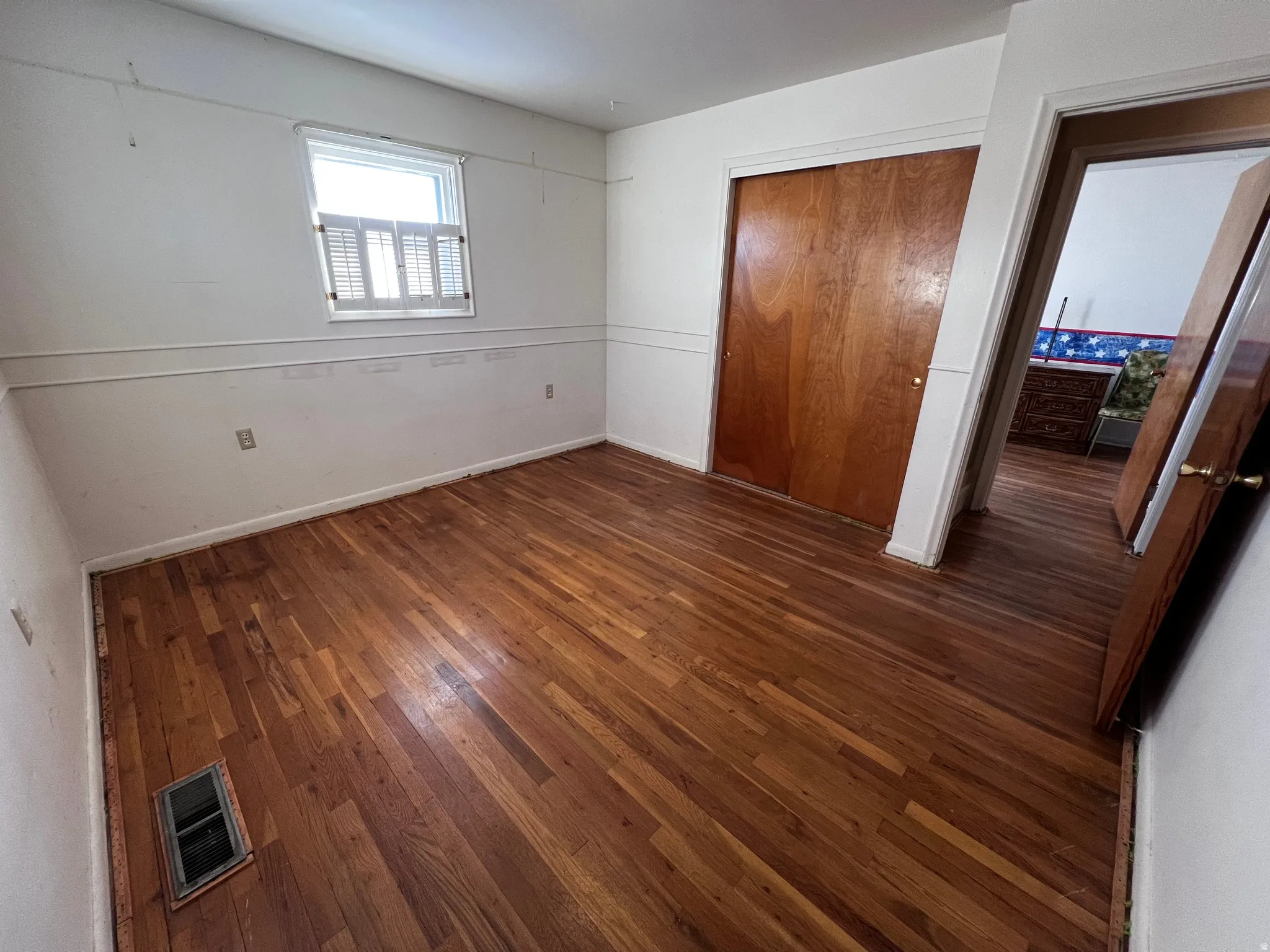 Unfurnished bedroom featuring a closet and dark wood finished floors