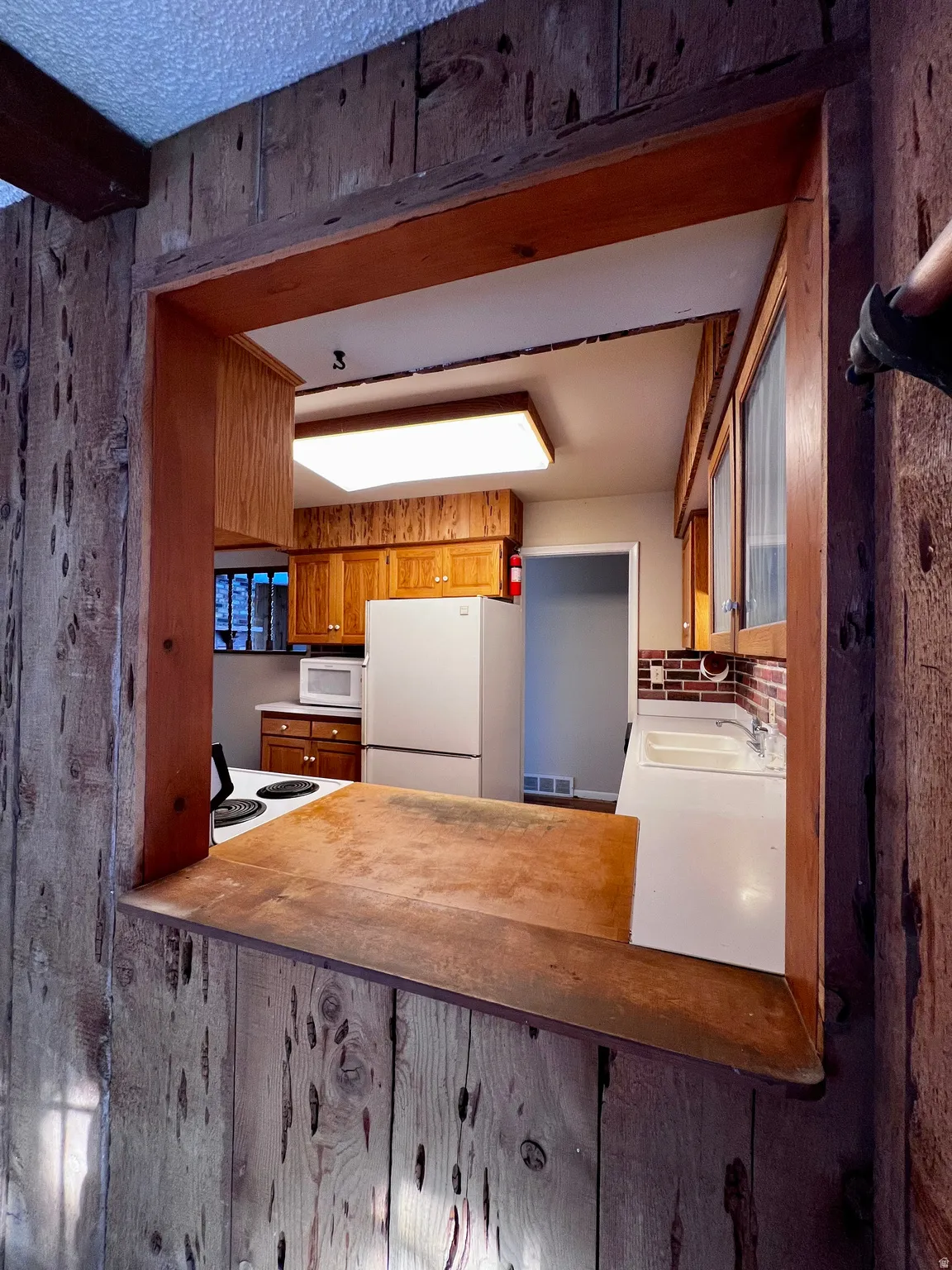 Kitchen with brown cabinets and white appliances