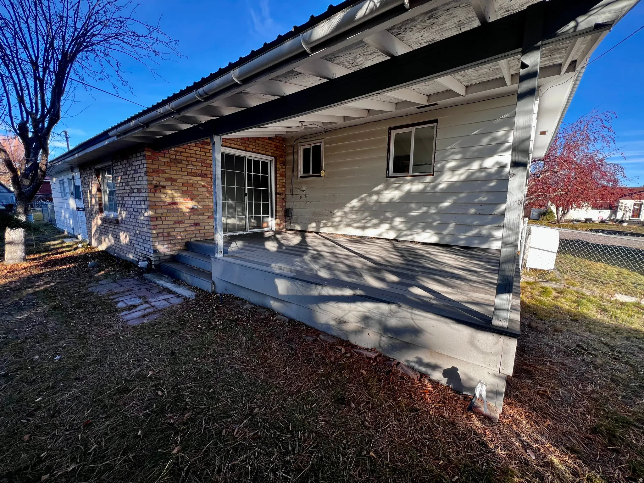 Back of house with brick siding and a wooden deck