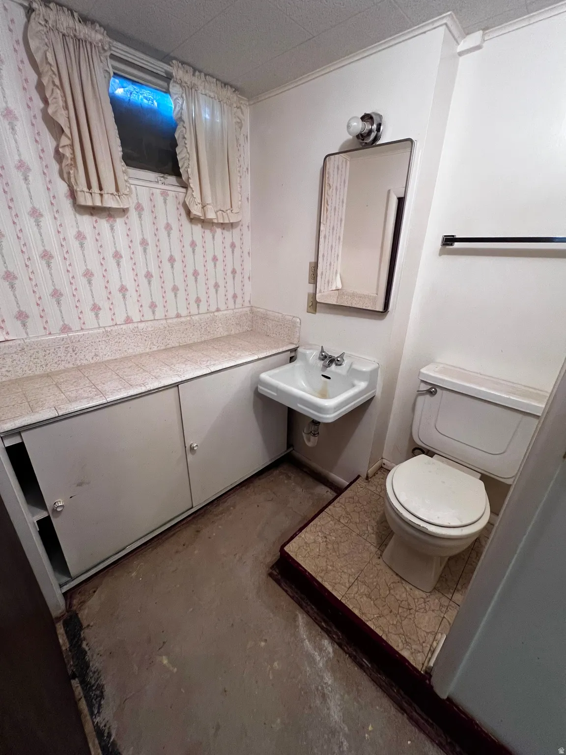Half bath with toilet and unfinished concrete floors