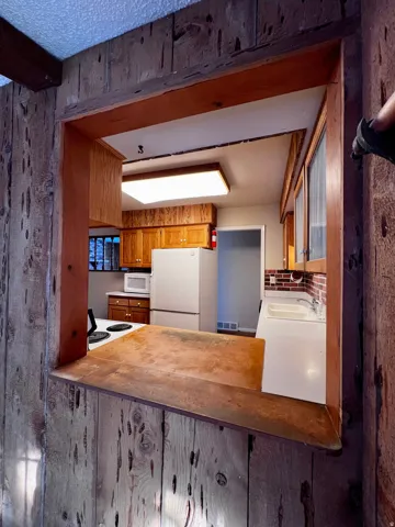 Kitchen with brown cabinets and white appliances