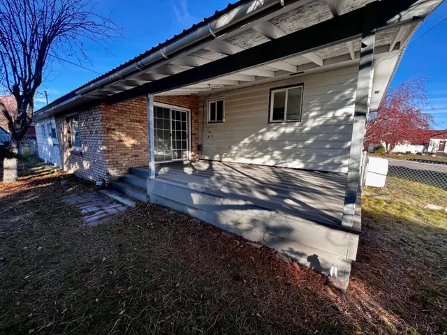 Back of house with brick siding and a wooden deck