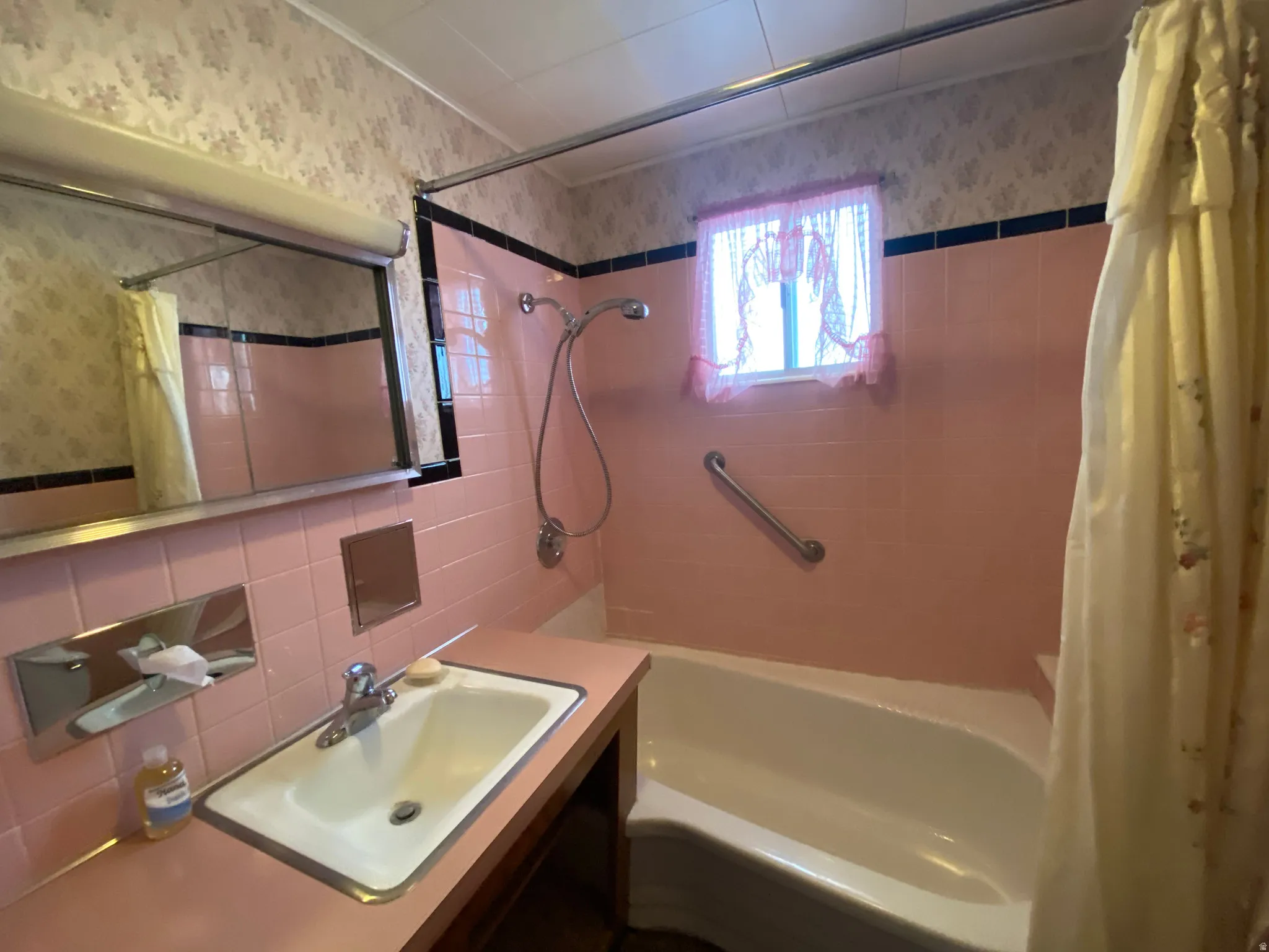 2nd full bath with shower / bath combo, vanity, wallpapered walls, tile walls, and decorative backsplash