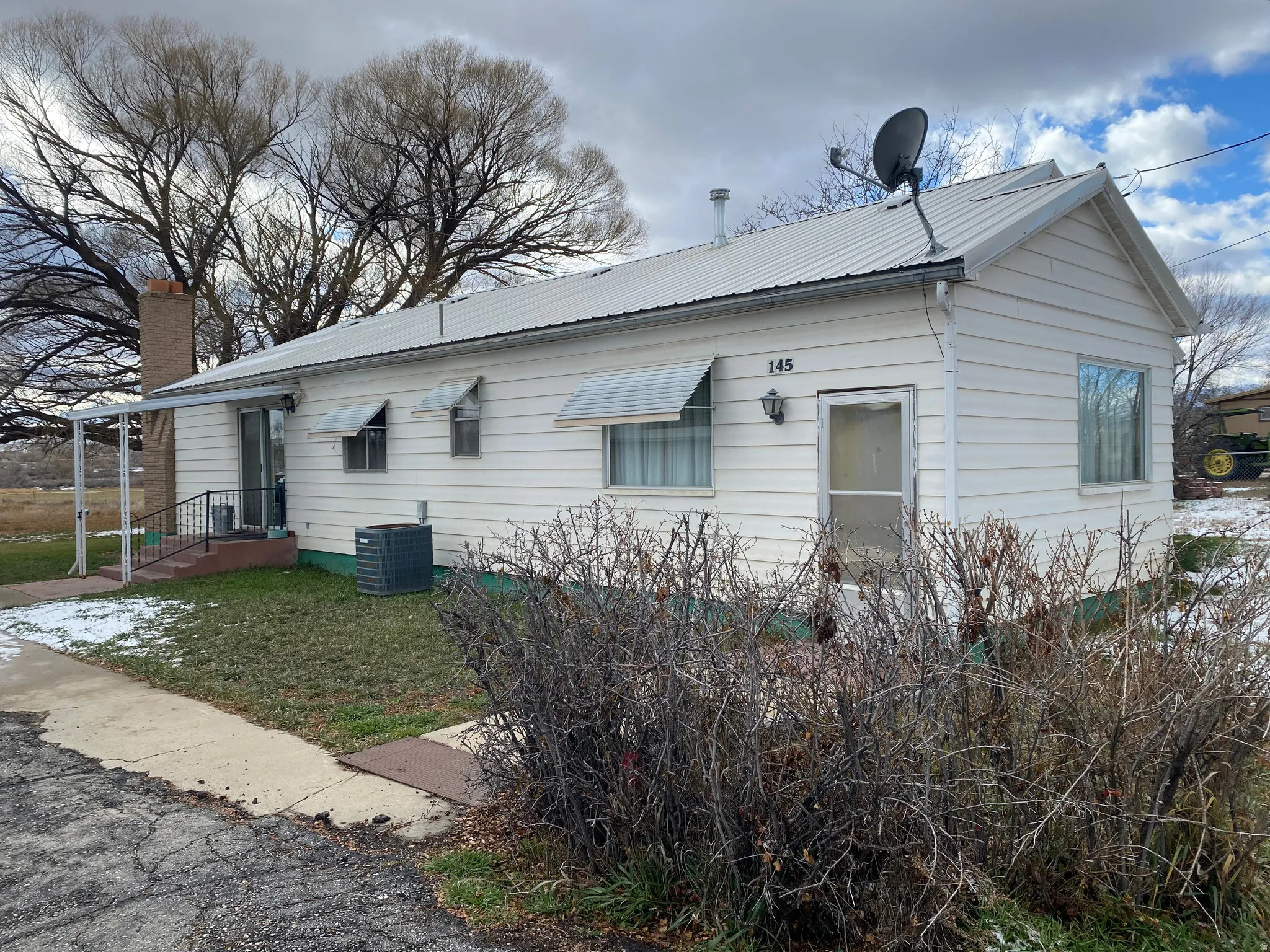 View of property exterior featuring a metal roof and a central air condition unit