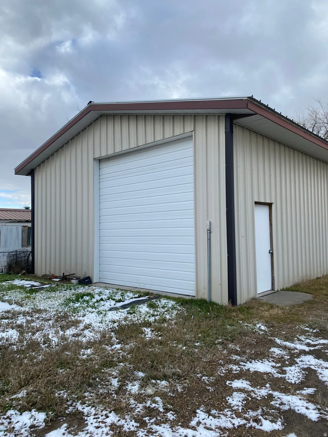 Large metal garage with two large 12 x 12 doors and attached shed/carport