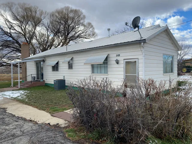 View of property exterior featuring a metal roof and a central air condition unit
