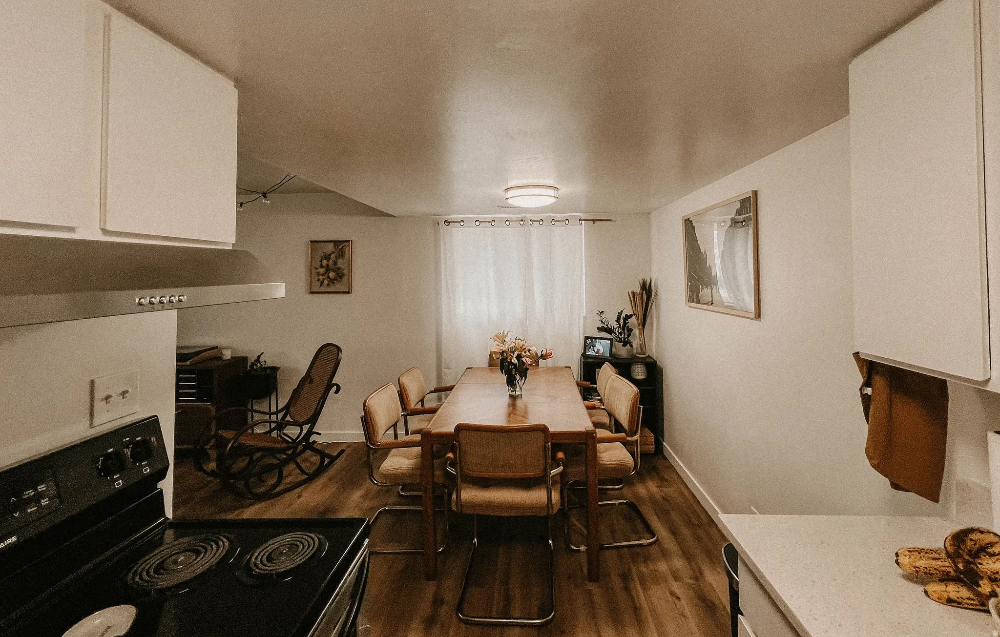 Dining space with dark wood-style floors and baseboards