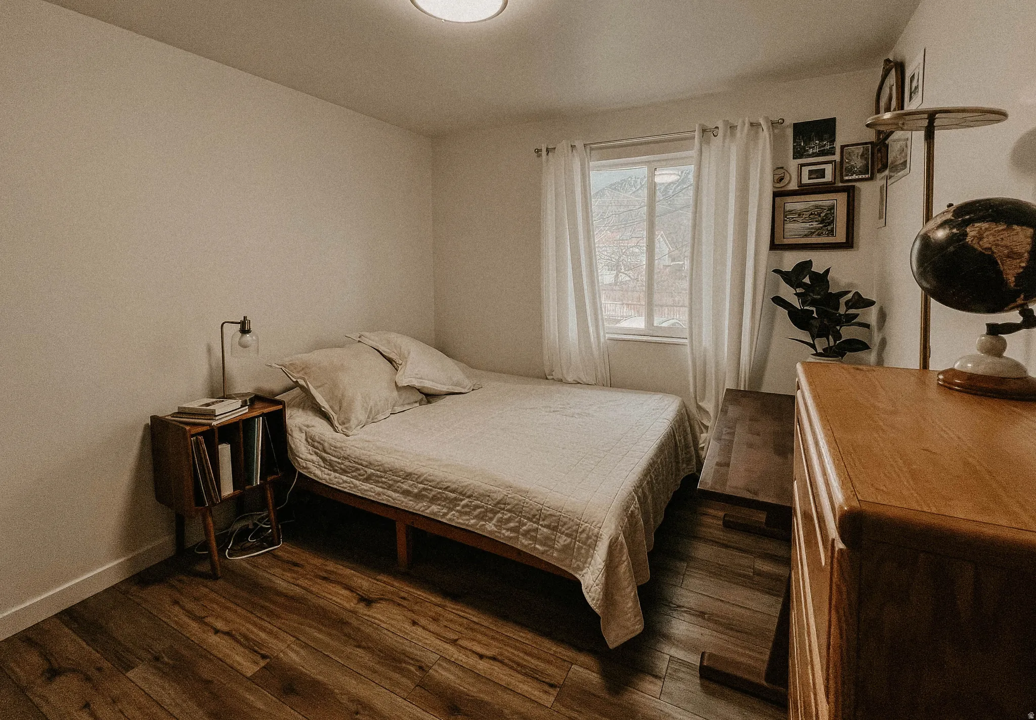 Bedroom with dark wood-type flooring and baseboards