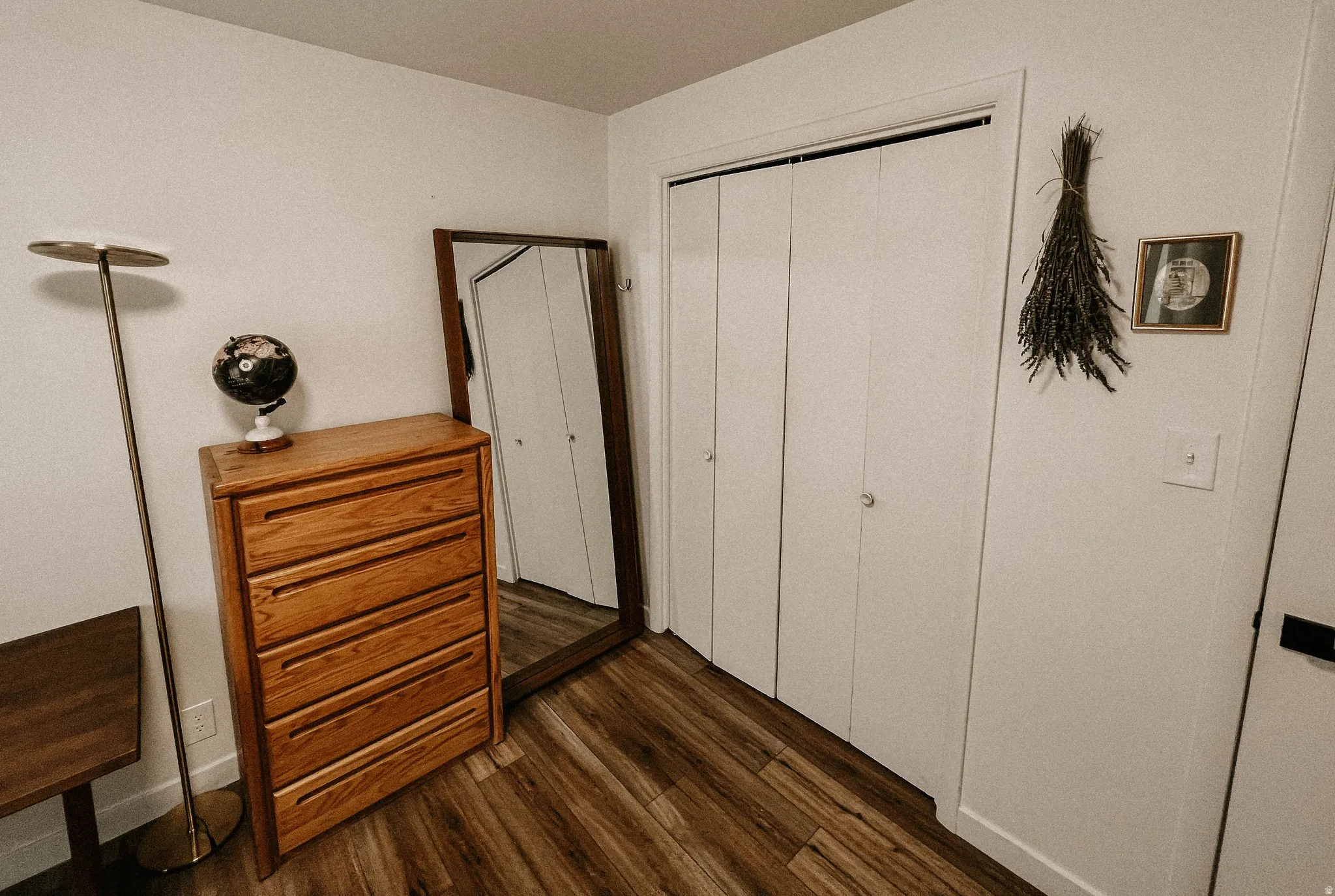 Bedroom with dark wood-style floors and a closet