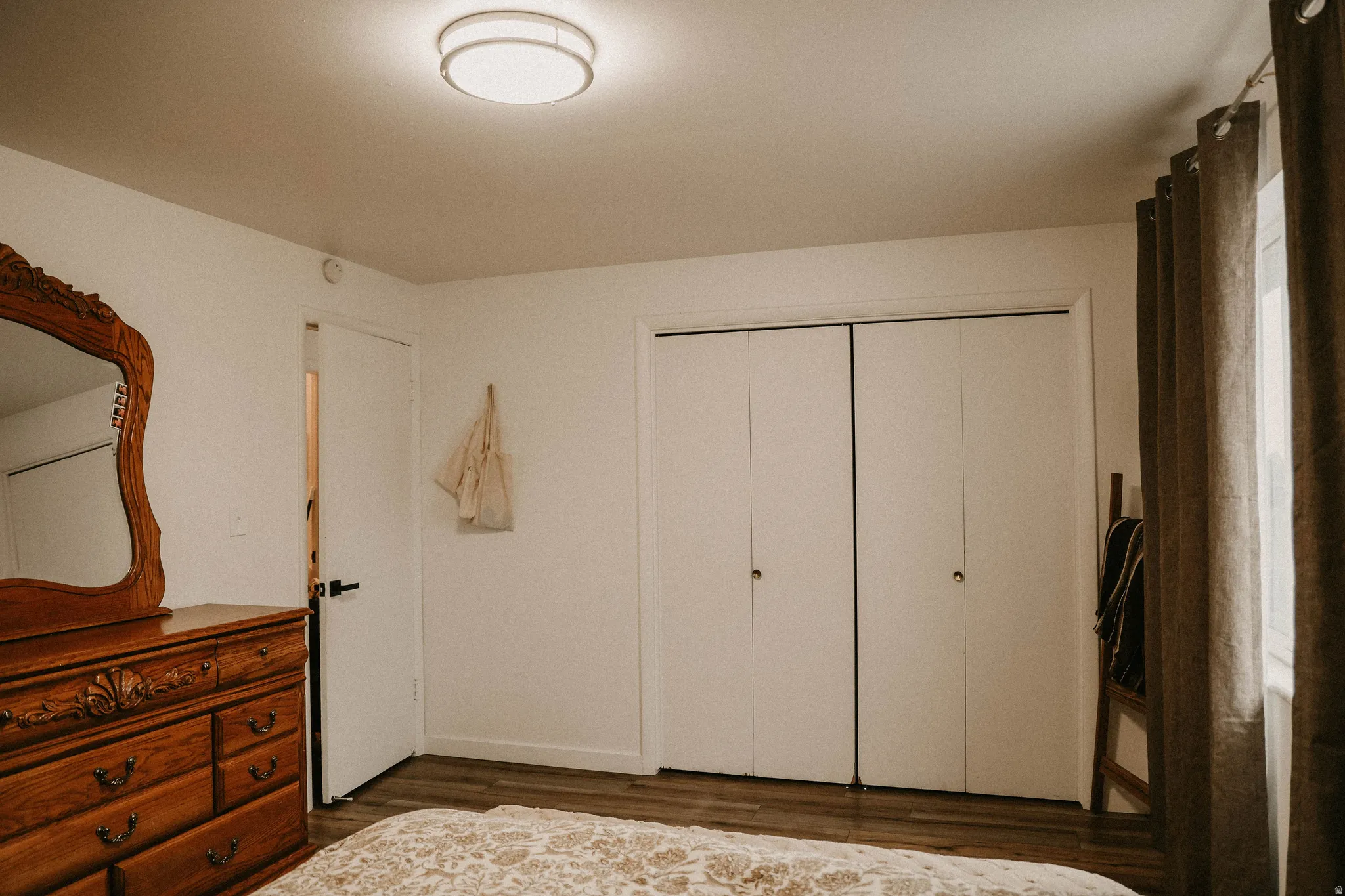 Bedroom with a closet and dark wood-type flooring