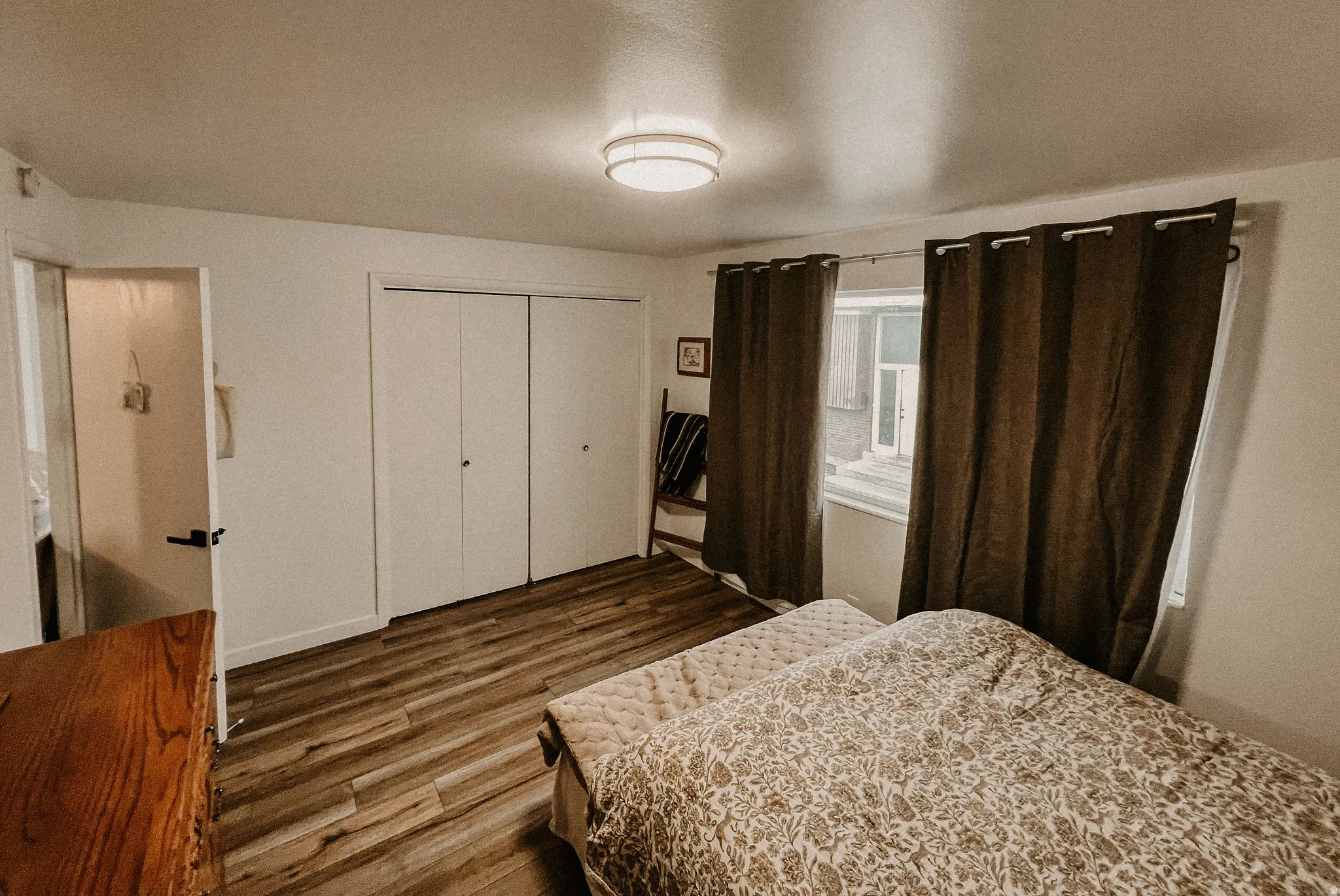 Bedroom featuring dark wood-type flooring and a closet