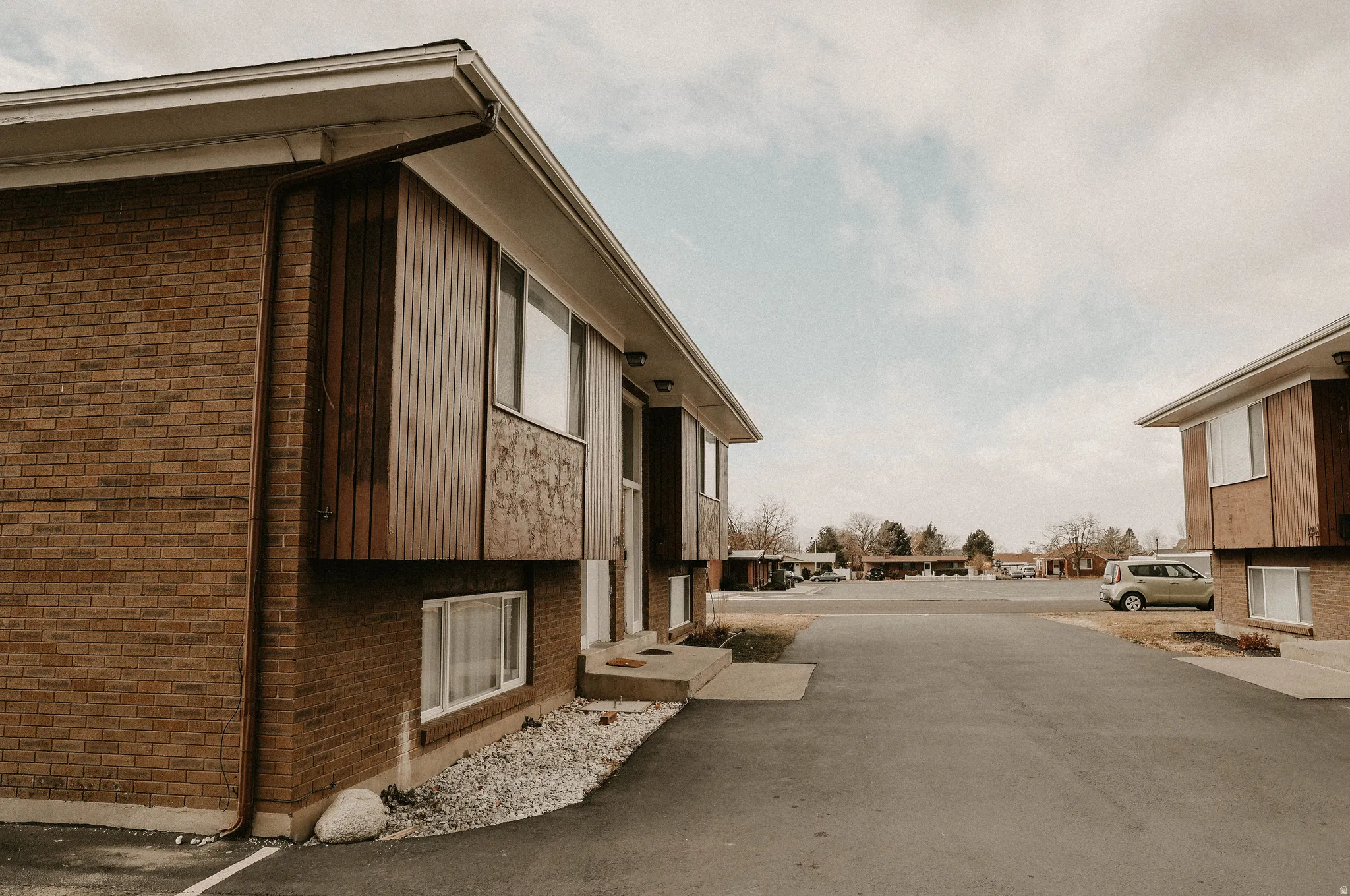 View of property exterior featuring brick siding and a residential view