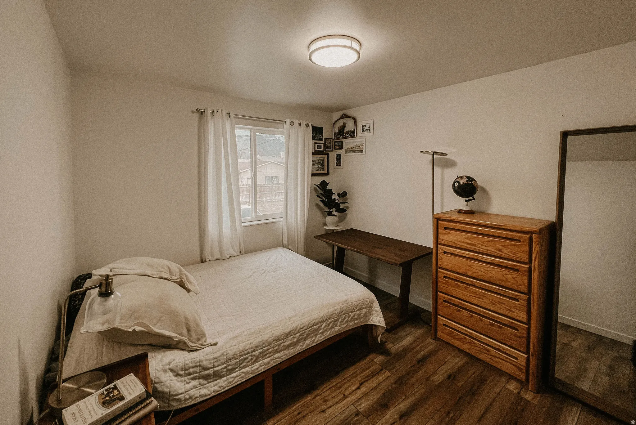 Bedroom featuring dark wood-type flooring and baseboards