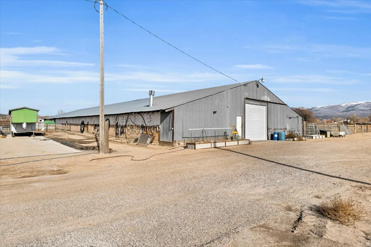 View of property featuring a detached garage, an outbuilding, and driveway