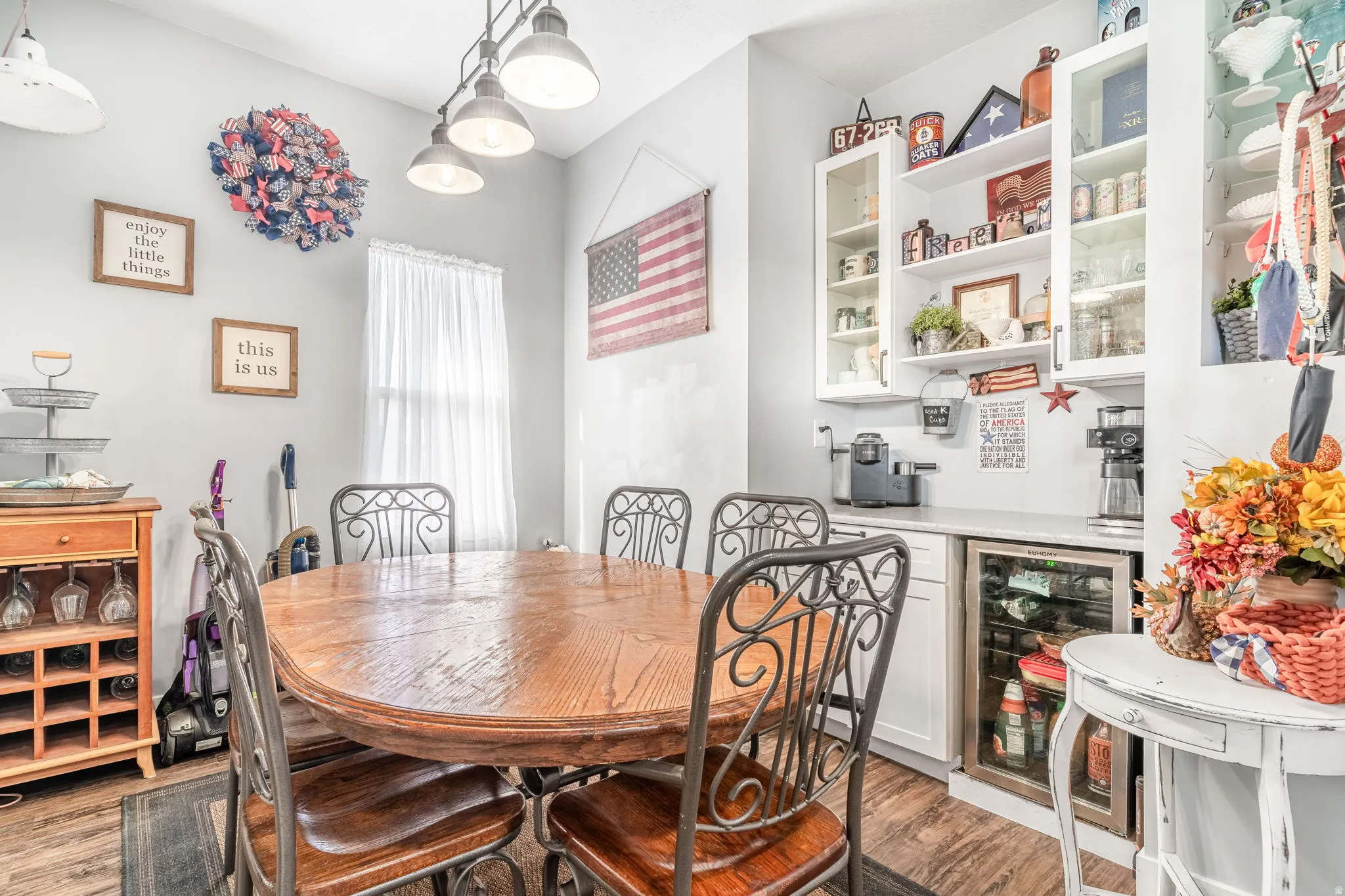 Dining room featuring wine cooler, light wood-style flooring, and a dry bar