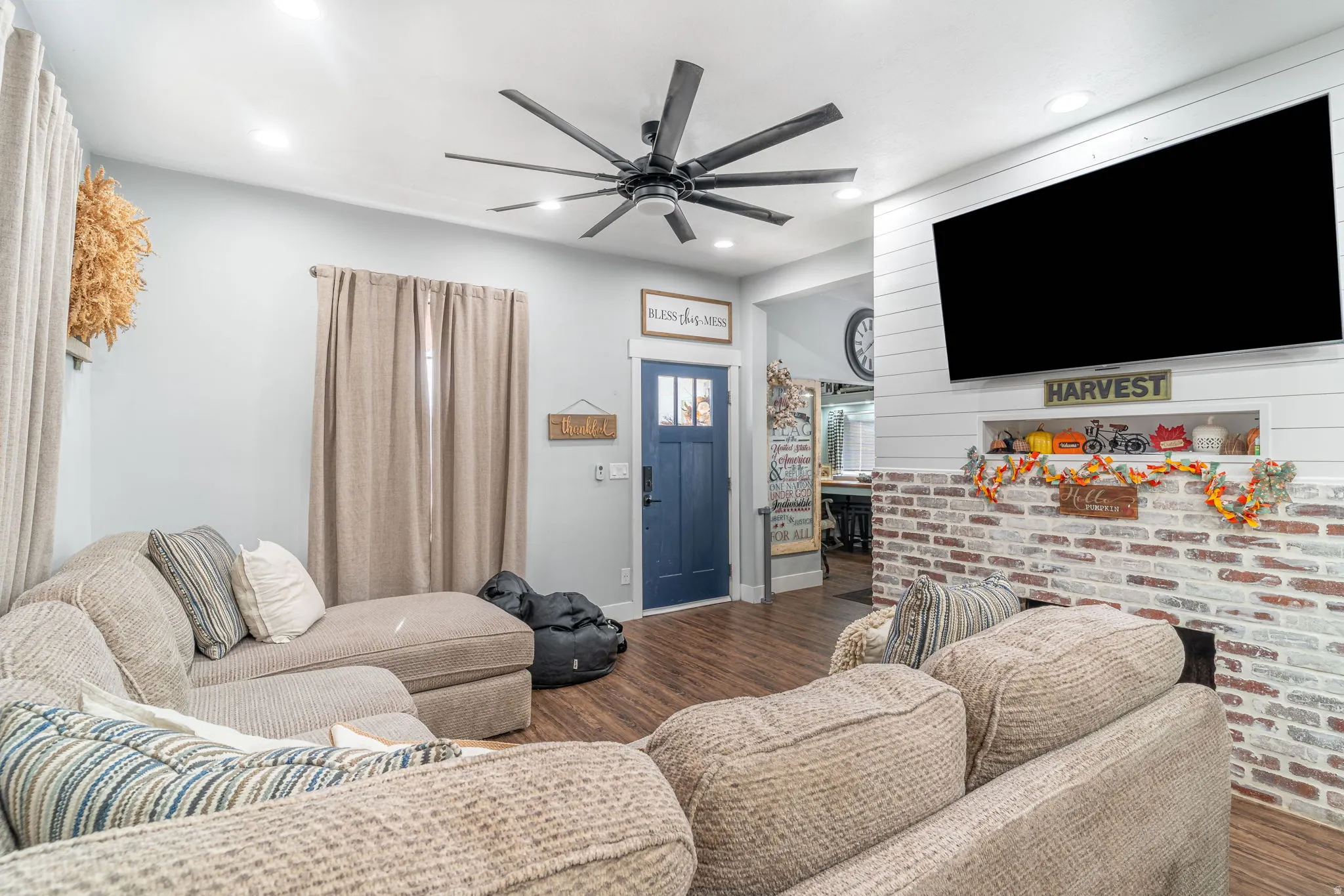 Living room with wood finished floors, ceiling fan, and recessed lighting