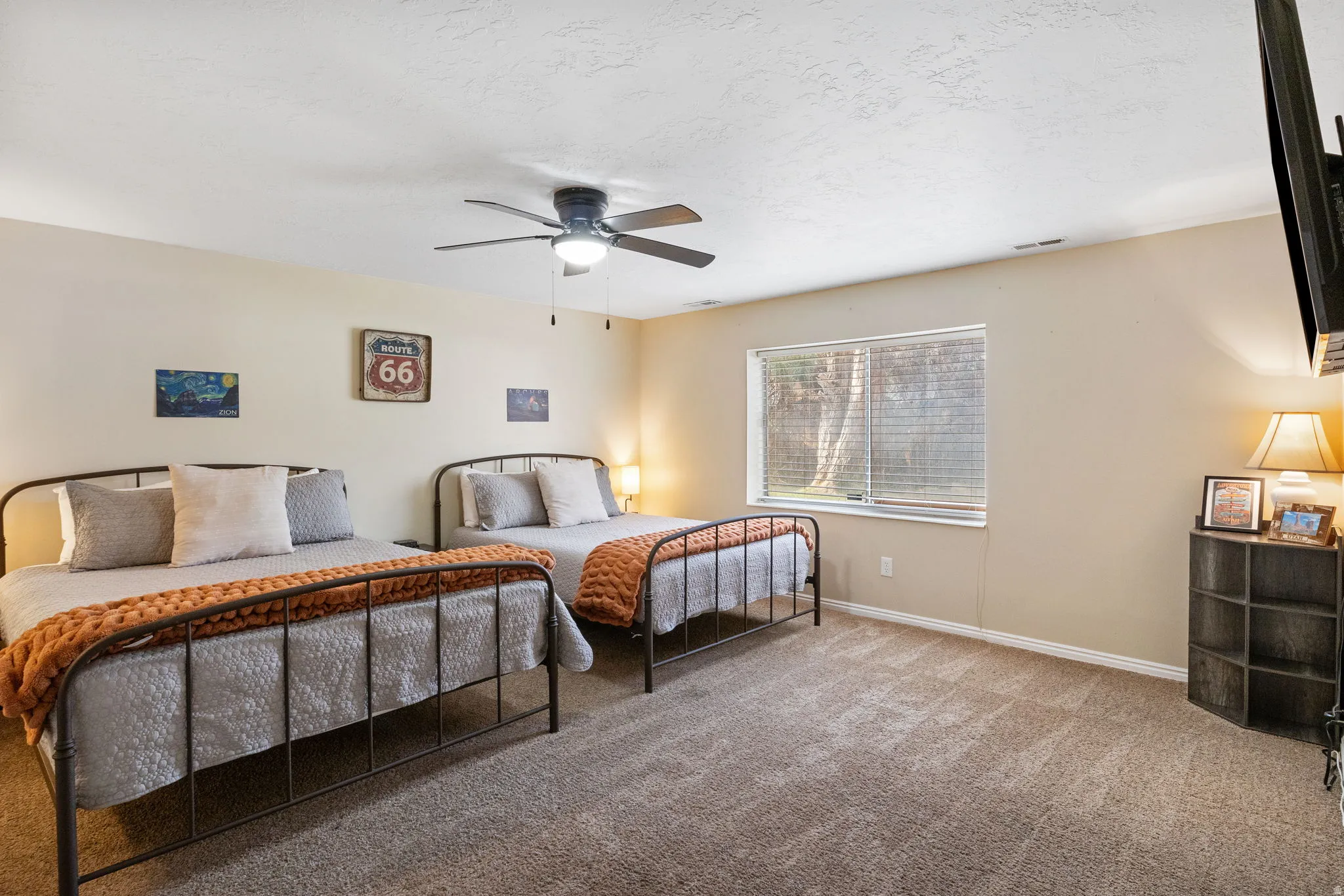 Bedroom with carpet floors, ceiling fan, and a textured ceiling