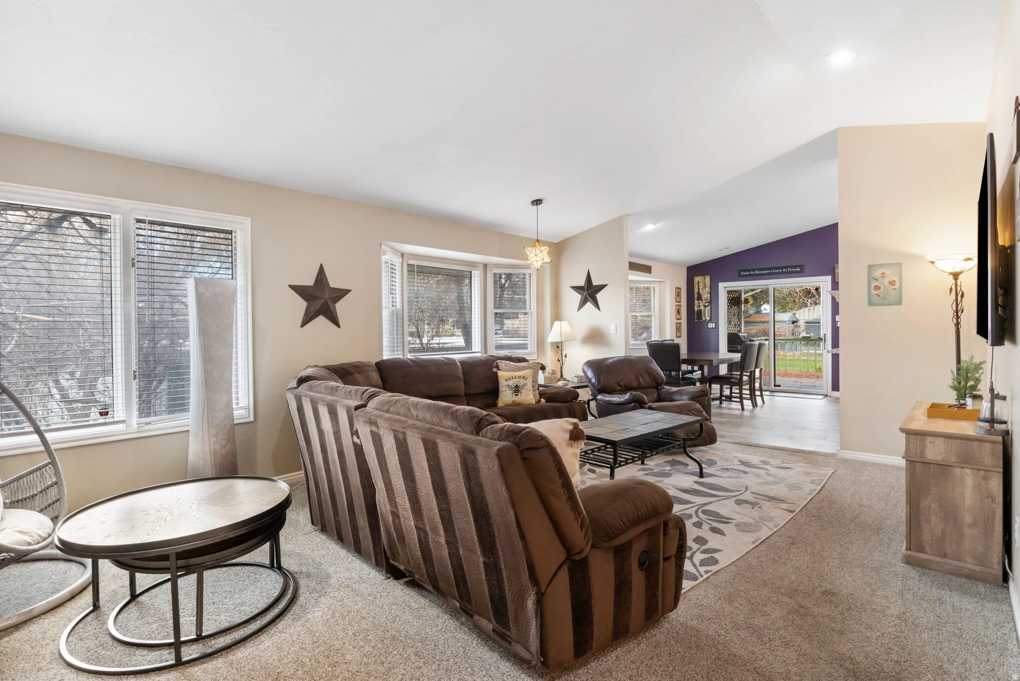 Living area with lofted ceiling and light carpet